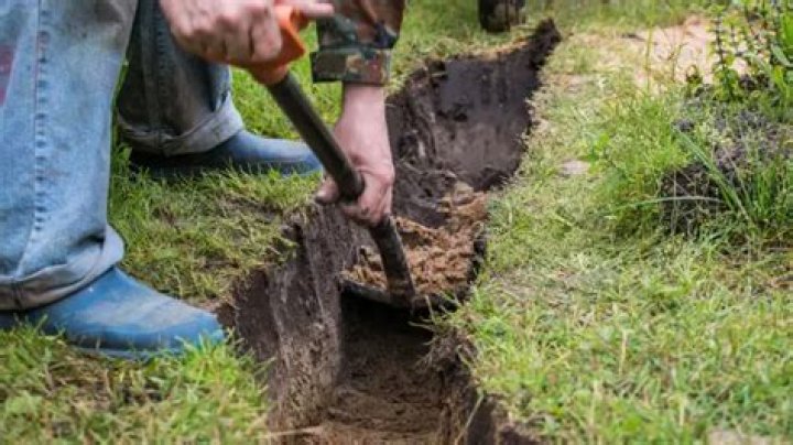 How do you dig a trench by hand?